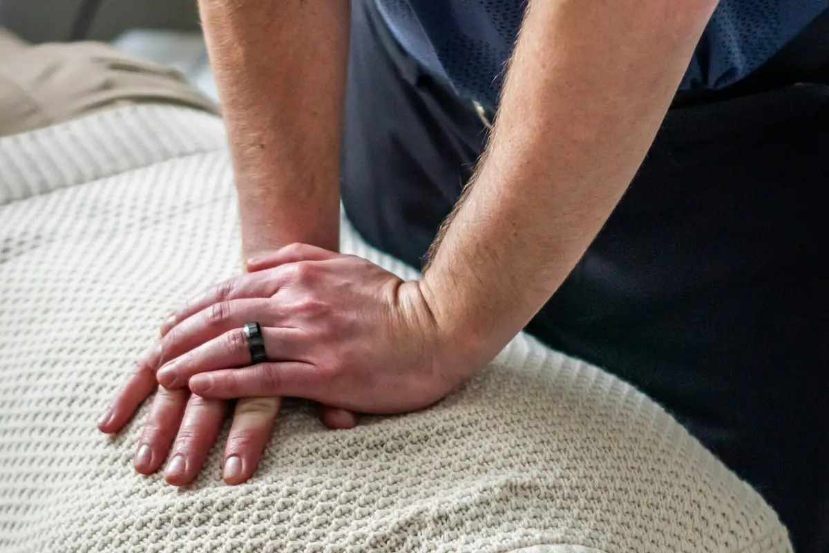 Clinician's hands performing a chiropractic adjustment on a patient's upper back